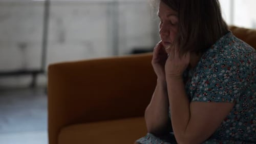 Woman Suffering From Depression Sitting on Sofa