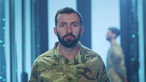 Man in Camo Stares Intently in Futuristic Room