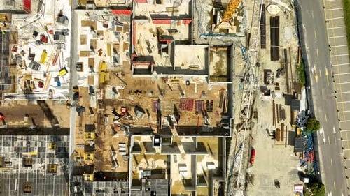 Vista desde arriba de una concurrida obra en construcción en Gdynia, con trabajadores, materiales y equipos visibles