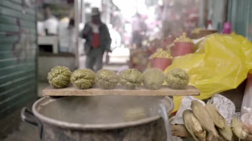 Some chayotes are being steamed on top of a big pot in a Mexican street market