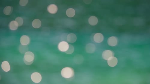 Abstract bokeh sunlight shining on a surface of turquoise lake