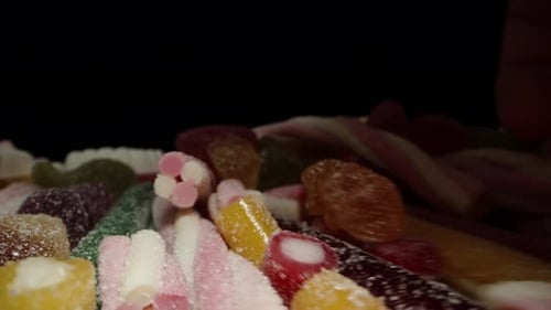 I take a handful of assorted gummy candies of various colors and shapes, dusted with sugar. Dolly