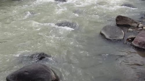 Water ripples and foam on rocky river