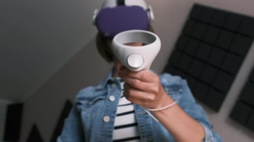 Young Adult Using VR Headset and Controllers