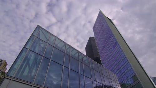 Clouds are Reflected in a Mirrored Glass Skyscraper in a Business District