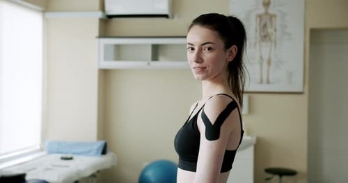 Woman with Athletic Tape on Shoulder in Doctor's Office