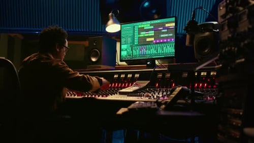 African American Producer Working at Mixing Panel in Recording Studio