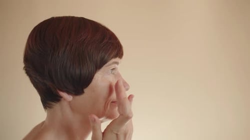 Side View Calm Caucasian Middleaged Mature Woman Applying Shooting Moisturizing