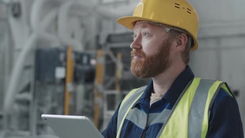 Bearded Factory Worker Using Digital Tablet