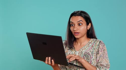 Женщина, составляющая письмо, тщательно печатает на клавиатуре ноутбука