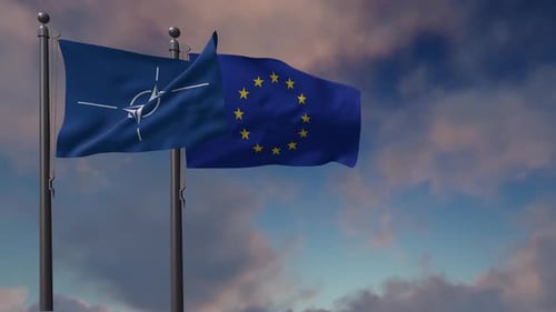 NATO and European Union Flags Waving Against Cloudy Sky