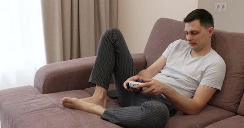 Man Relaxing on Couch Playing Video Games