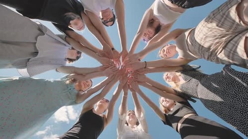 Group of Friends is Standing in a Circle Joining Their Hands Together Outdoors