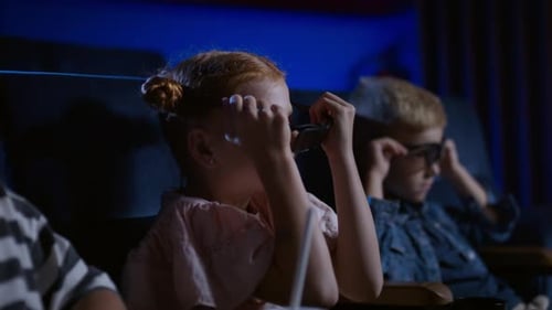 Children at the cinema watching a 3d movie with excitement and joy