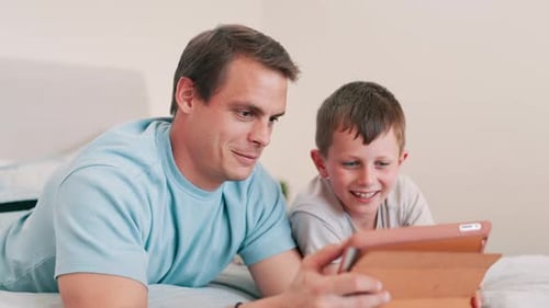 Father and Son Enjoying Tablet Together at Home