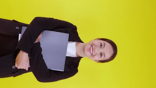 Portrait young asian businesswoman hold folder document smile on yellow background.