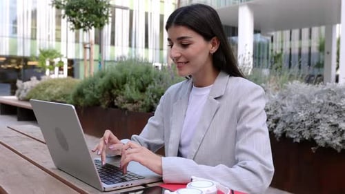 Businesswoman Working on Laptop Sitting Outdoors at Corporate Office Area