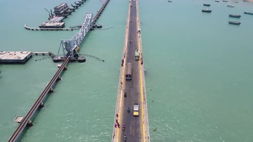 aerial drone shot of Rameshwaram city, with the bridge as a striking focal point over the sea.