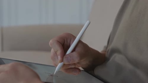 Man Using Stylus to Draw on Digital Tablet