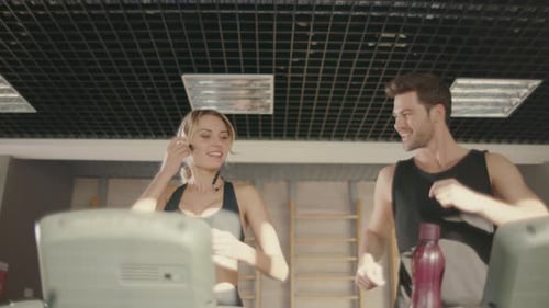 Joyful Fitness Couple Talking on Treadmill Machine in Gym Club. Cheerful Man