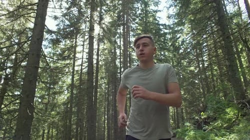 A Man Jogging in a Green Forest