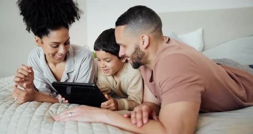 Family Uses Tablet Together on Bed at Home