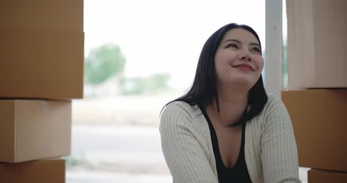 Young Woman Smiles Amongst Shipping Boxes