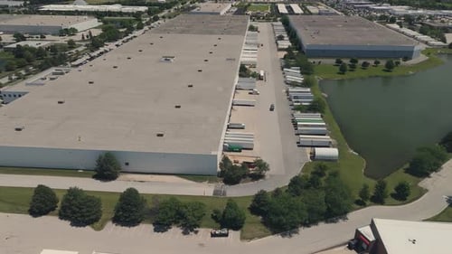 Warehouse with Semi Trucks and Cargo Trailers Aerial Wide Footage at Sunny Day