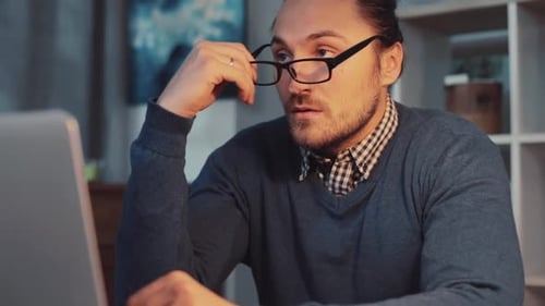 Un professionnel concentré qui travaille tard dans la nuit devant son ordinateur portable dans un espace de travail moderne