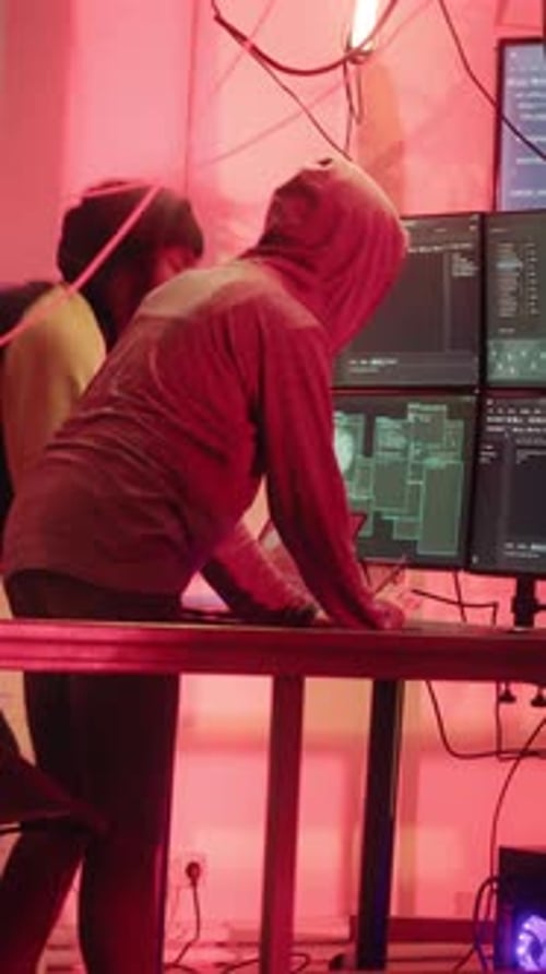 Hackers Working at Computers in Dark Room