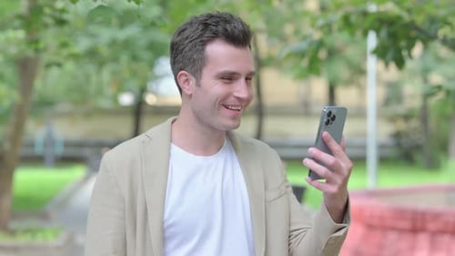 Man Communicating on Smartphone in City Park