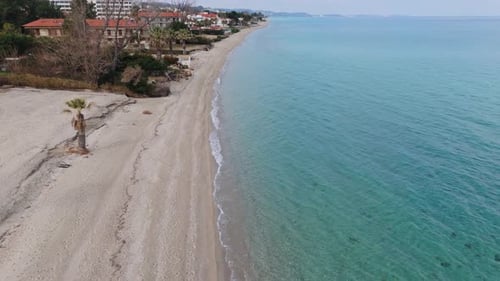 Aerial view over sandy beach - coastline with hotels and rolling waves