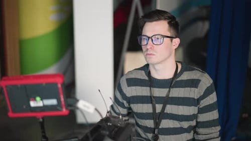 Camera Operator Adjusting Equipment and Monitoring Camera Setup in Tv Studio