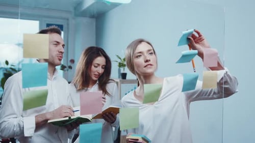 Team Collaborating Using Sticky Notes in a Modern Office