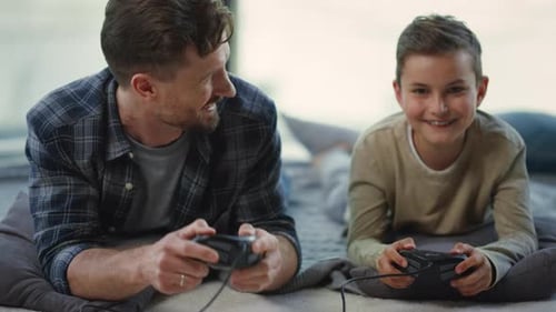 Father and Son Play Video Games Together at Home