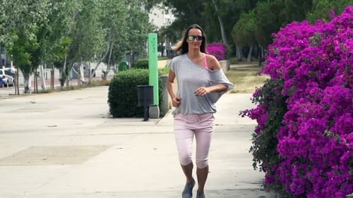 Young woman jogging in city park super slow motion training outdoors
