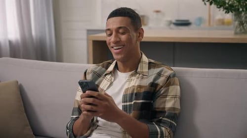 Young Adult Smiling Using a Modern Smartphone