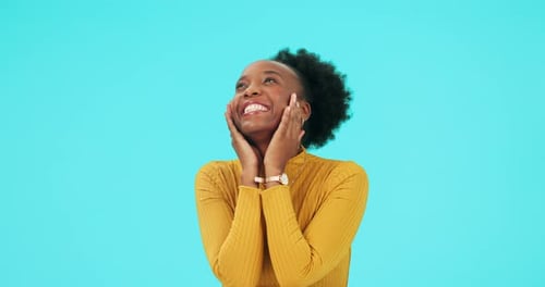 Smiling Woman Looks Up Against Blue Background