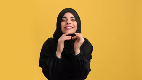 Portrait Smiling Turkish Woman in Black Hijab Screaming Secret Posing Isolated on Orange Studio