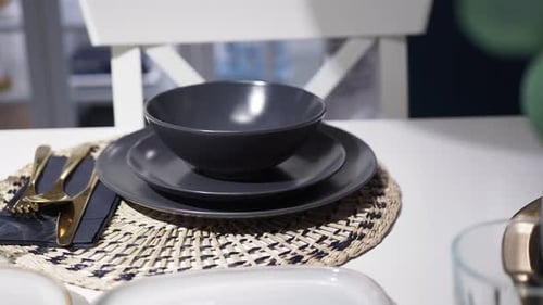 Elegant Table Setting with Grey Dishes and Gold Cutlery