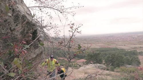 Couple Hiking Down Mountain Trail on Cloudy Day