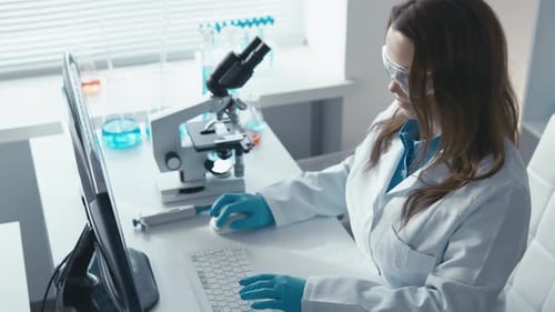 Woman Scientist Typing at Desk in Laboratory
