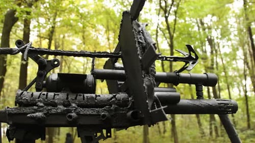 Black Metal Gun Sculpture in Forest