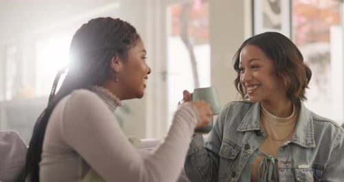 Two Friends Laughing and Drinking Coffee Indoors
