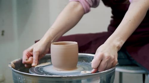 Pottery firing. Close up shot of artist making ceramic pot on pottery wheel at workshop.