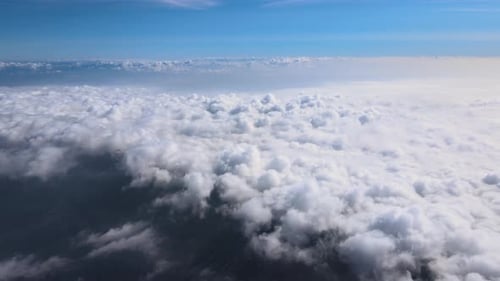 Aerial View From Airplane Window at High Altitude of Earth Covered with Puffy Cumulus Clouds Forming