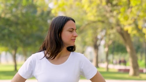 Woman Doing Neck Stretches in Urban Park