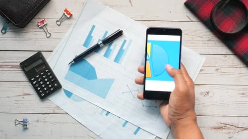 Young Man Analyzing Financial Chart on Smart Phone