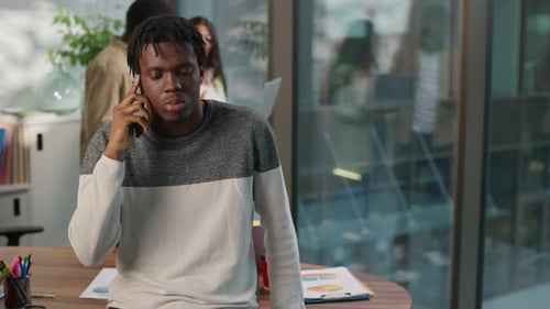 Focused Young Adult Talking on Phone in Office