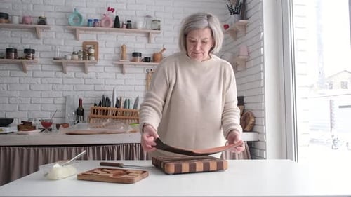 Woman Prepares Fish in Bright Home Kitchen